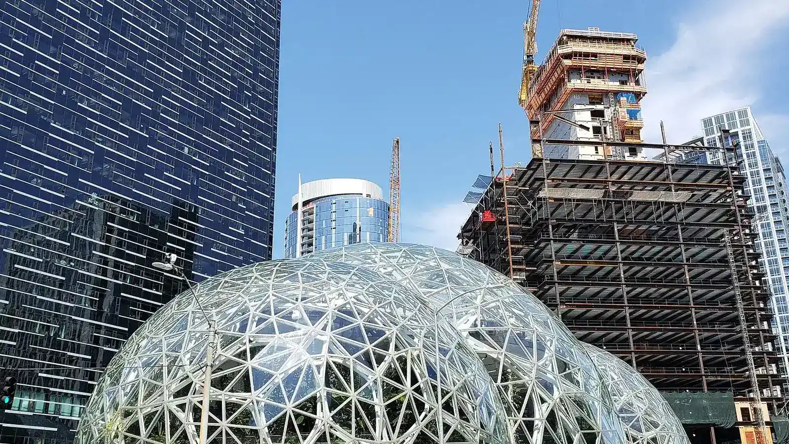 Стеклянные купола-сферы штаб-квартиры Amazon среди офисных высоток и строительных кранов